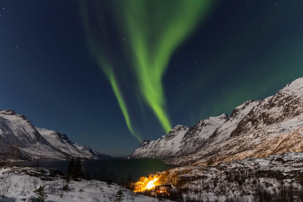 Northern lights over snowy mountains in Norway